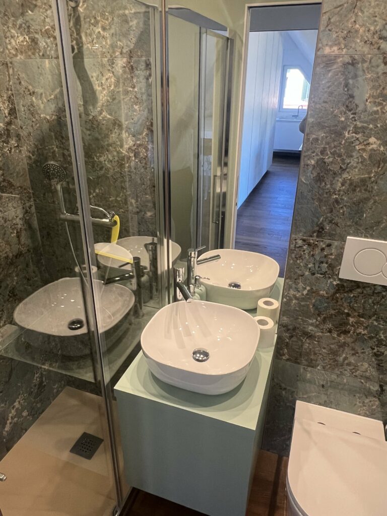 Bagno con rivestimento in piastrelle di marmo composito con specchio integrato